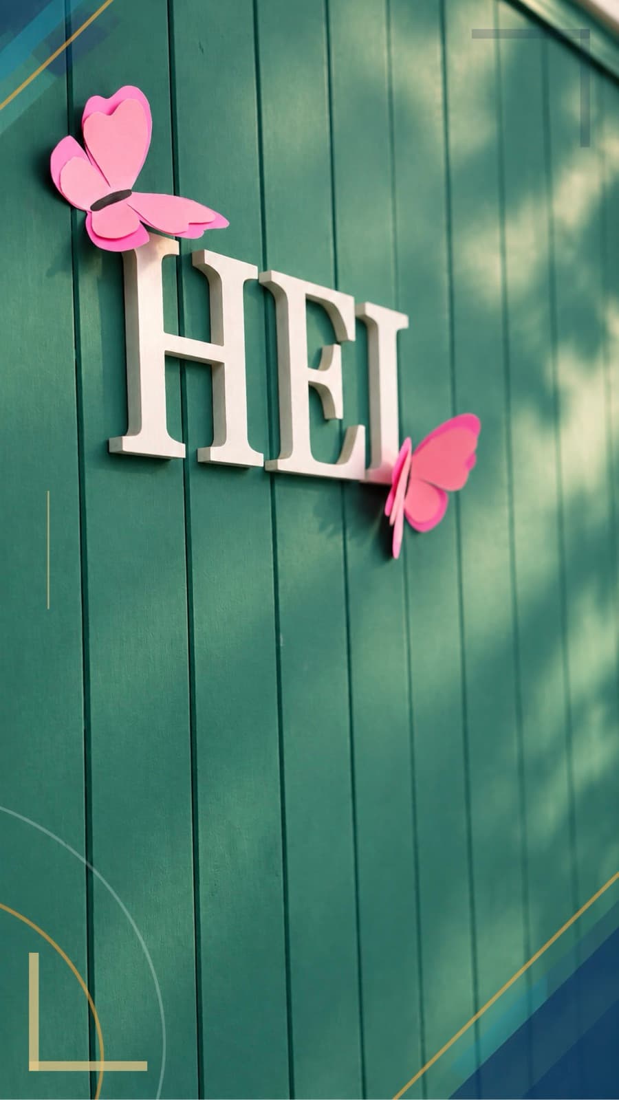 Letras HEI y mariposas de papel sobre la pared verde del instituto.