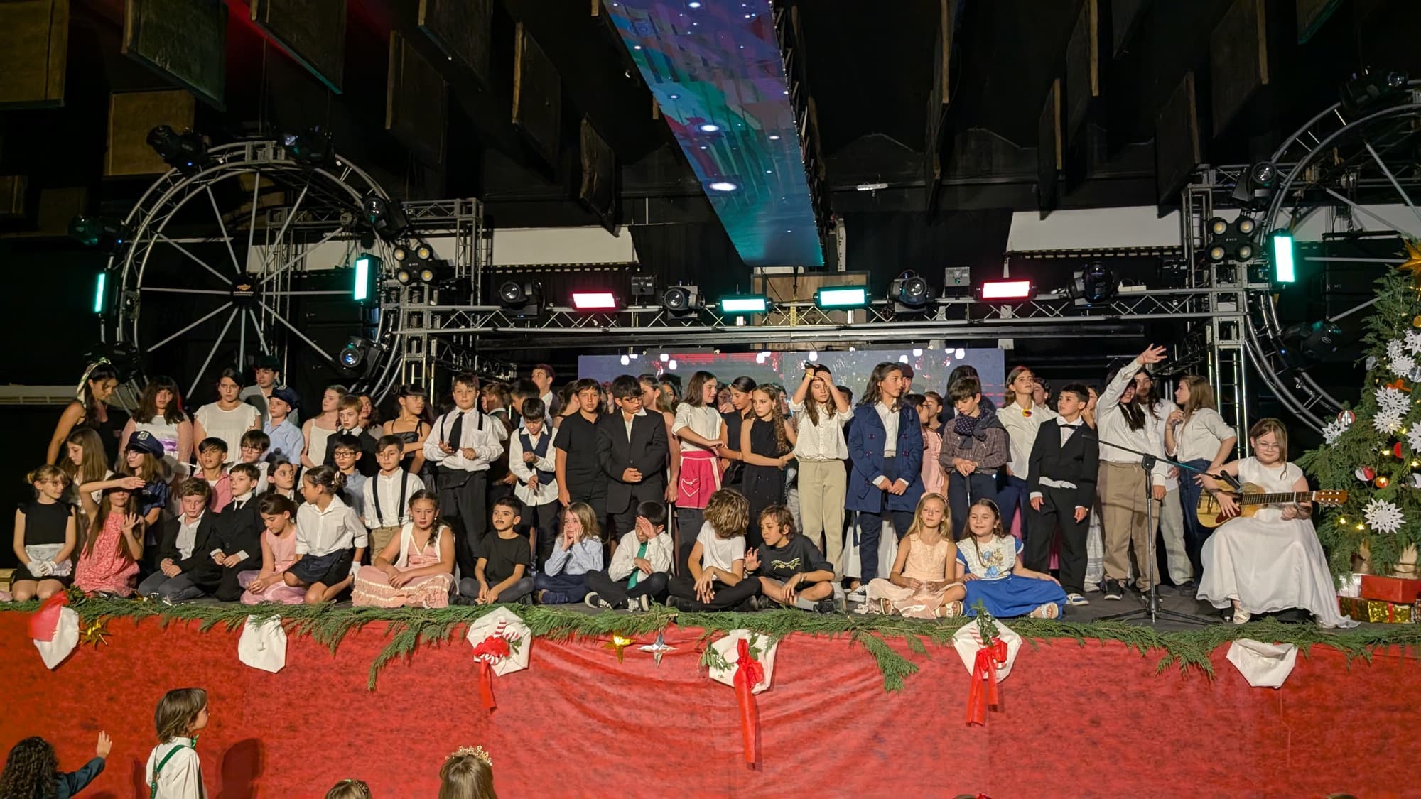 Alumnos adolescentes en el escenario durante el show de fin de año.
